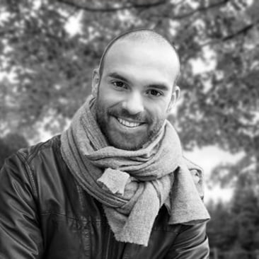 a black and white photo of a man wearing a scarf.