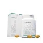 A white bottle and box labeled "10% CBD softgels capsules – Cibdol" with three yellow capsules in the foreground.