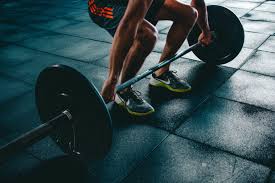 a man squats with a barbell in his hands.