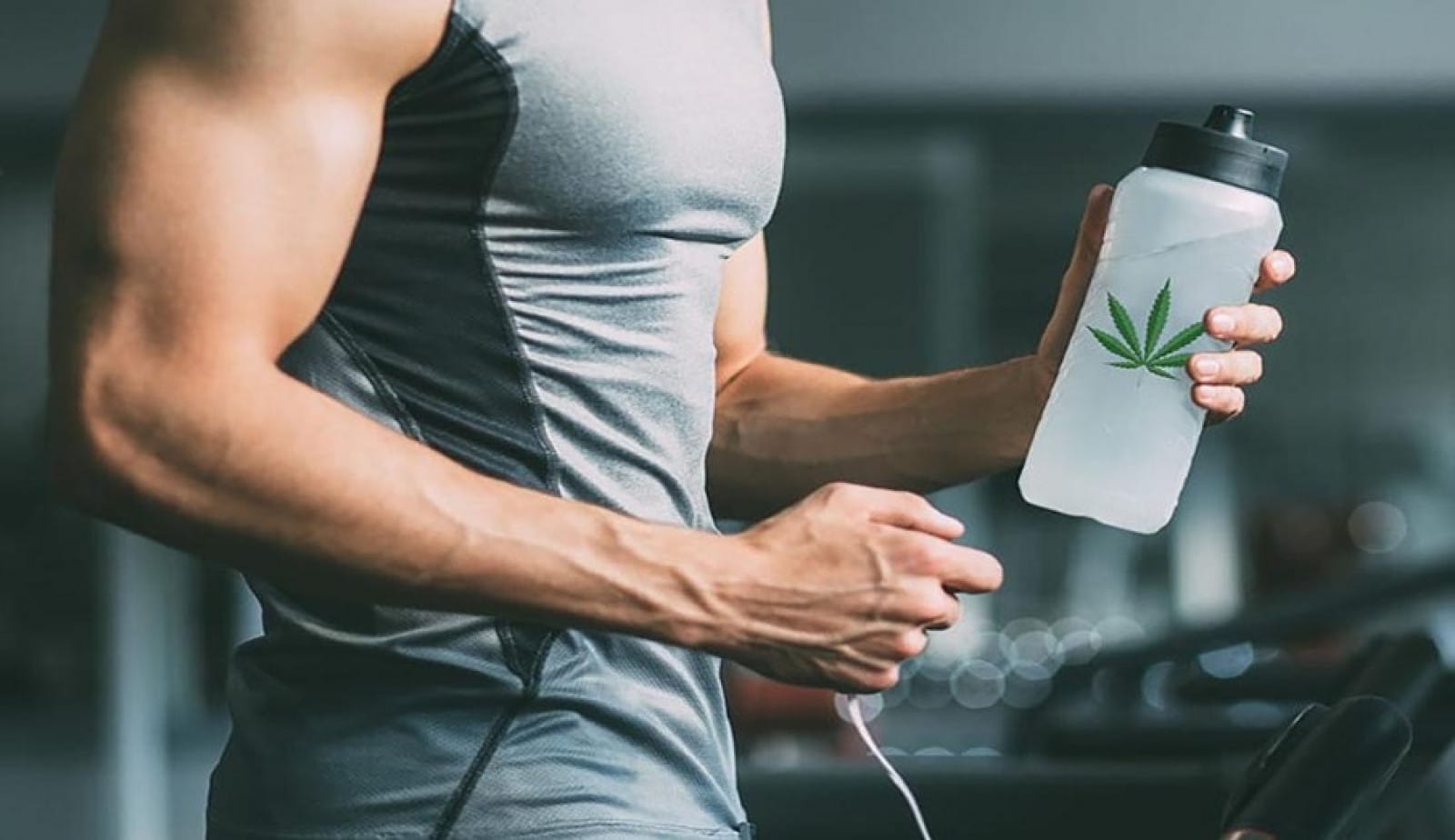 a man holding a water bottle with a marijuana leaf on it.